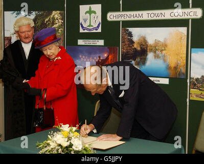 La reine Elizabeth II de Grande-Bretagne regarde le duc d'Édimbourg signer le livre du visiteur à l'hôtel de ville de Chippenham, Wiltshire, lors d'une visite de la ville. Elle a voyagé en train régulier avec le duc d'Édimbourg pour une journée d'engagements dans la région. * y compris une visite à l'usine Dyson. Banque D'Images