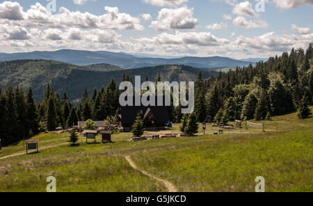Hala Rycerzowa mountain meadow avec petit chalet, sentiers de randonnée et les collines de l'arrière-plan dans les montagnes Beskid Zywiecki Banque D'Images