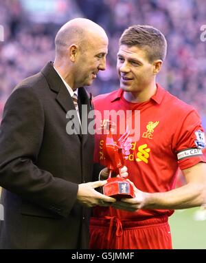 Le capitaine de Liverpool Steven Gerrard reçoit un prix de l'ancien équipier Gary McAllister en reconnaissance de son 600e appétence pour le club Banque D'Images