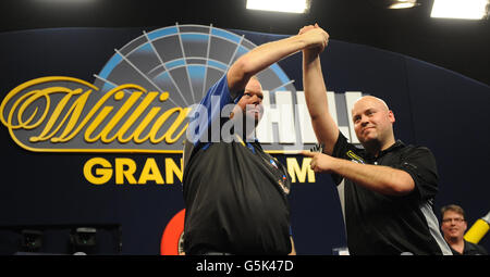 Raymond van Barneveld (centre) est félicité par Christian Kist après sa victoire aux quarts de finale. Banque D'Images