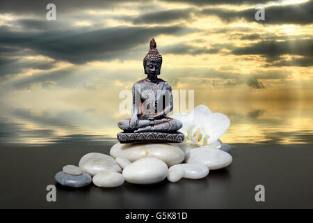 Bouddha zen stone,blanc,fleurs d'orchidées et le fond de ciel Banque D'Images