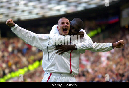 Photo de la bibliothèque PA datée du 6/10/01 le capitaine de l'Angleterre David Beckham (avant) célèbre avec son coéquipier Emile Heskey après avoir obtenu l'égaliseur d'un coup de pied gratuit contre la Grèce dans les dernières secondes du match du groupe de qualification européen Nine de la coupe du monde de la FIFA à Old Trafford, Manchester. Les fans de football d'Angleterre et d'Irlande découvrirent aujourd'hui, samedi 1er décembre 2001, que leurs équipes joueront au premier tour de la coupe du monde. Le tirage au sort, qui doit avoir lieu lors d'une cérémonie spéciale à Busan, en Corée du Sud, décidera où et quand l'équipe de Sven Goran Eriksson et les hommes de Mick McCarthy commenceront leur Banque D'Images