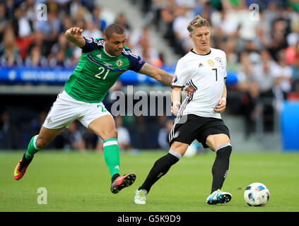 L'Irlande du Nord Josh Magennis (à gauche) et l'Allemand Bastian Schweinsteiger (à droite) bataille pour la balle durant l'UEFA Euro 2016, Groupe C match au Parc des Princes, Paris. Banque D'Images