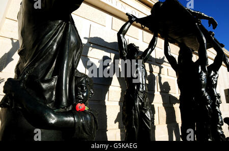 Un coquelicot sur une statue au Mémorial des Forces armées pendant le jour de l'armistice et le dimanche du souvenir à l'Arboretum du Mémorial national, à Alrewas, dans le Staffordshire. Banque D'Images