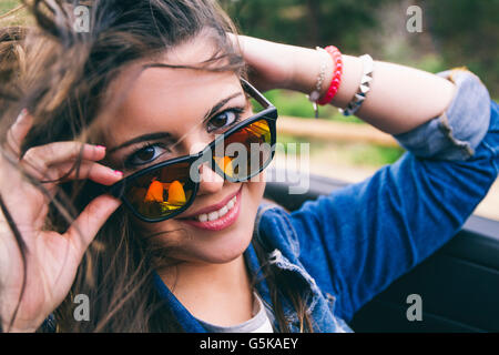 Hispanic woman peering over sunglasses Banque D'Images