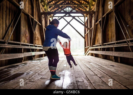 Mère de race blanche et sa petite fille sur le pont couvert Banque D'Images