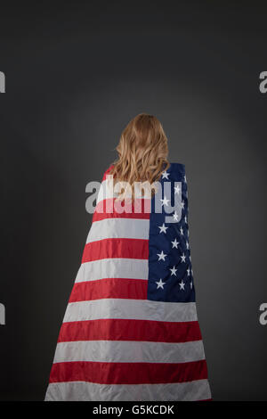 Mixed Race woman wrapped in American flag Banque D'Images