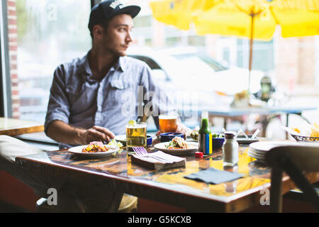 Caucasian man eating tacos in restaurant Banque D'Images