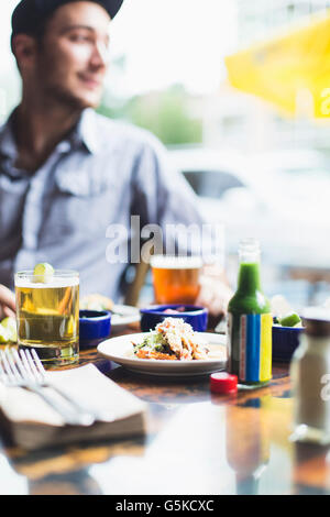 Caucasian man eating tacos in restaurant Banque D'Images