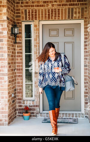 Hispanic woman walking on/stoop Banque D'Images