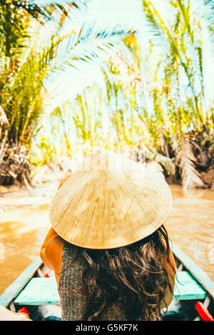 Caucasian woman floating en bateau sur la rivière rural Banque D'Images