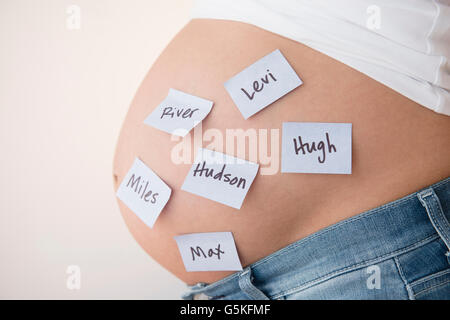 Femmes enceintes Caucasian woman with name suggestions sur le ventre Banque D'Images