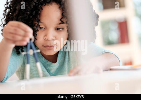 African American girl using compass in science classroom Banque D'Images
