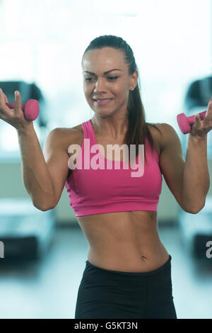 Boxer musculaire essaie de savoir quoi faire avec des haltères dans une salle de sport - Fitness Sport Modèle Bodybuilder Banque D'Images