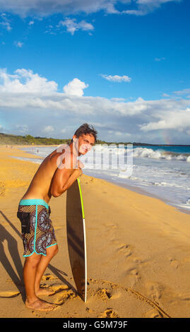 Skimboarder à grande plage à Makena State Park avec aperçu de rainbow Banque D'Images