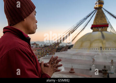 Un moine en prière en face de Boudhanath, Vallée de Katmandou, UNESCO World Heritage Site, Népal Banque D'Images