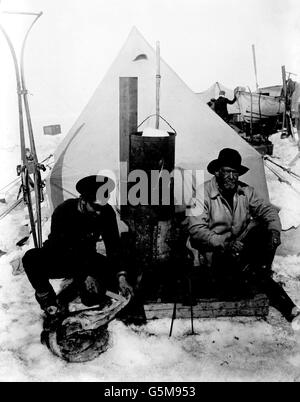 1916: Sir Ernest Shackleton (r) et Frank Hurley devant leur tente sur la banquise dérivante appelée 'camp de patience'. Au milieu, on peut voir le poêle sur lequel toute la cuisson a été faite, le combustible étant des peaux de bécher et de pingouins. M. Huley a pris toutes les photos de l'expédition. Banque D'Images