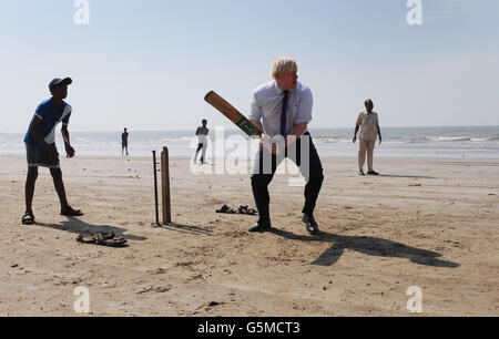 Le maire de Londres Boris Johnson joue aujourd'hui au cricket avec les garçons des écoles locales de Mumbai sur Juhu Beach en Inde après avoir rencontré les réalisateurs de Bollywood. Banque D'Images