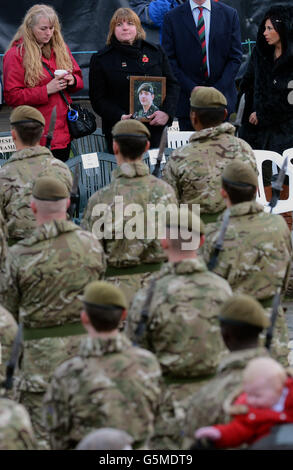 Monica Kershaw la mère du soldat Chris Kershaw, qui a été tuée avec cinq de ses camarades lorsque leur véhicule blindé Warrior a été soufflé, tient une photographie de son fils, alors que des soldats du troisième Bataillon, The Yorkshire Regiment, assistent à un défilé de retour à Piece Hall, Halifax, Comme les parents de dix soldats du régiment qui ont perdu la vie après leur déploiement en Afghanistan regardent. Banque D'Images