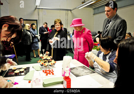 Son Altesse Royale la reine Elizabeth II admire des gâteaux de tasse à Hartcliffe & Withywood Ventures, au centre Gatehouse de Hartcliffe, à Bristol, où elle-même et le duc d'Édimbourg visitent les installations, rencontrent le personnel et les personnes qui utilisent le centre. La Reine a également dévoilé une plaque pour commémorer sa visite. Banque D'Images