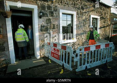 Un employé de Scotland Gas Networks discute avec le propriétaire clair Bawn car 2,500 foyers restent sans chauffage central ni eau chaude pendant une troisième journée. Banque D'Images