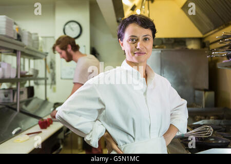 Caucasian chef smiling in restaurant kitchen Banque D'Images
