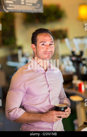 Hispanic businessman drinking coffee in coffee shop Banque D'Images