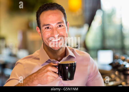 Boire du café barista hispaniques in coffee shop Banque D'Images