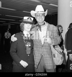 L'acteur Larry Hagman, 48 ans, qui joue J.R. Ewing à Dallas, pose avec la policière Julie Rooke, 22 ans, à son arrivée à l'aéroport de Gatwick. Il doit apparaître sur l'émission de chat de Terry Wogan à la BBC. Banque D'Images