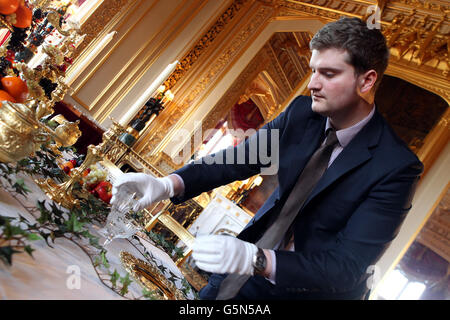 David Oakey, conservateur de l'exposition Royal Collection Trust, apporte la touche finale à une table dans la salle à manger de l'État, qui est agrémentée de pièces du Grand Service, le magnifique service de restauration de la dorure argentée commandé par George IV de Royal Goldsmiths, Rundell, Bridge & Rundell, Dans le cadre de l'exposition de Noël victorienne au château de Windsor, Berkshire. Banque D'Images