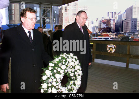 Le premier ministre d'Irlande du Nord, David Trimble (à gauche), et le vice-premier ministre, Mark Durkan, se doivent de rendre hommage après avoir déposé une couronne au Ground Zero à New York, un cadeau de la population d'Irlande du Nord.* ...En arrière-plan est la zone où les deux tours étaient autrefois debout, le travail continue encore aujourd'hui pour éliminer les débris. Banque D'Images