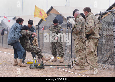 Le Sergent Waysidine (au centre) enseigne aux membres de l'Armée nationale afghane, de la police nationale afghane et de la police uniforme afghane des moyens de détecter les engins explosifs improvisés (DEI) comme WO2 Gary Liddle (deuxième à droite) du comté de Durham (deuxième à droite) Et le Sergent Tony Wild de Londres (à droite) du 101 Engineer Regiment (EOD) regarde la FOB Shawqat, province Helmand, Afghanistan. Banque D'Images