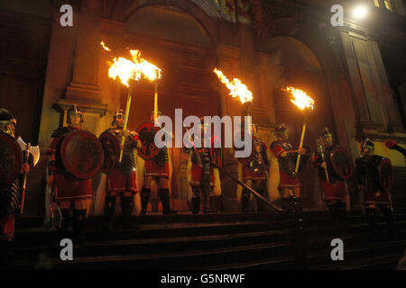 Les gens prennent part à une procession aux flambeaux à travers Édimbourg dans le cadre des célébrations pré Hogmanay. Banque D'Images