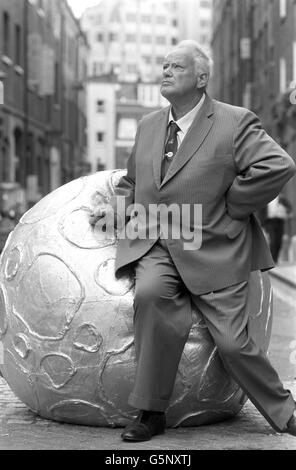 L'astronome Patrick Moore pose avec un astéroïde gonflable devant le Cambridge Theatre, dans le West End de Londres, où il se produit dans la comédie musicale Return to the Forbidden Planet. Banque D'Images