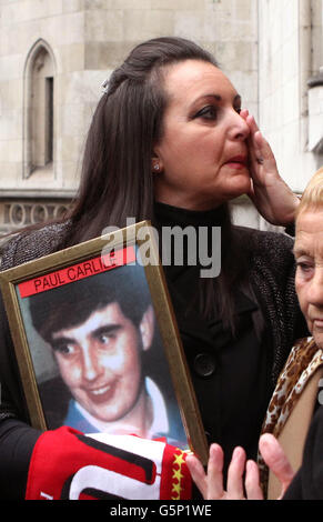 Donna Miller, a une photo de son frère Paul Carlile alors qu'elle quitte la High court à Londres, après que le tribunal ait annulé les verdicts d'enquête de mort accidentelle d'origine retournés après que 96 fans de football de Liverpool sont morts dans l'écrasement à Hillsborough il y a 23 ans. Banque D'Images