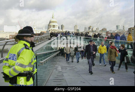 La police garde un œil sur la foule tandis que les premiers marcheurs traversent le pont du Millénaire, au-dessus de la Tamise, après avoir été rouvert à Londres, après une modification de 5 millions.* le pont de 18.2 millions a osciller sous le poids de milliers de piétons lorsqu'il a ouvert en juin 2000.Après seulement trois jours, les exploitants du pont ont dû fermer la structure de 320 mètres de long, qui va de la cathédrale Saint-Paul au nord de la Tamise à Londres à Tate Modern sur la rive sud. Banque D'Images