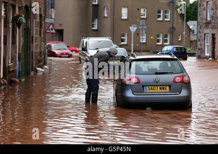 Temps d'hiver 23 décembre.Un homme voit sa voiture inondée dans la rue haute de Stonehaven, près d'Aberdeen, après de fortes inondations. Banque D'Images