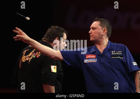 Kevin Painter en action contre Adrian Lewis (à gauche) lors du troisième tour du Championnat du monde des fléchettes Ladbrokes.com à Alexandra Palace, Londres. Banque D'Images