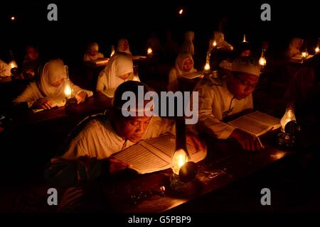 21 juin 2016 - Solo, Central Java, Indonesia - SOLO, INDONÉSIE - JUIN 21 : Les élèves internat islamique Mustafa Baitul lire le Coran par l'éclairage des lampes à huile ou à Mojosongo semprong appelé village le 22 juin 2016 dans la ville de Solo, le centre de Java, en Indonésie. Cette activité dans le cadre de la révélation du Coran et plus proche de la nature et d'éduquer les élèves afin de diligence lire le Coran, surtout pendant le Ramadan. (Crédit Image : © Sijori des images à l'aide de Zuma sur le fil) Banque D'Images