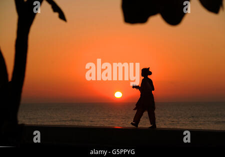 Une jeune fille porte des fleurs le long de Marine Drive tandis que le soleil se couche sur la mer arabe à Mumbai, Inde PRESSE ASSOCIATION photo. Date de la photo: Jeudi 29 novembre 2012. Le crédit photo devrait se lire: Anthony Devlin/PA Banque D'Images