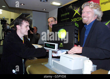 Scott Rawlins, 22 ans, de Heathrow reçoit la première Xbox de Sir Richard Branson (R) et Chris Lewis, directeur de la division Xbox Consumer, à Virgin Megastore à Londres.* il est le premier à acheter la console de jeu très attendue de Microsoft qui est en vente à minuit et espère rivaliser avec PlayStation 2. Banque D'Images