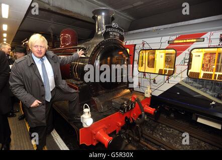 Le maire de Londres Boris Johnson admire le moteur du train à vapeur Metropolitan, après son arrivée à la station de métro Moorgate dans la City de Londres, pour célébrer le 150e anniversaire de l'ouverture du réseau ferroviaire souterrain de Londres, où il s'est arrêté après un voyage d'Olympia dans l'ouest de Londres. Banque D'Images