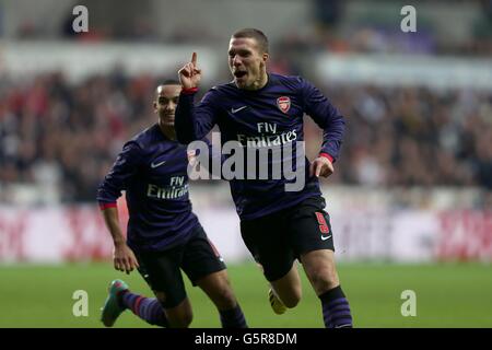 Lukas Podolski (à droite) d'Arsenal célèbre le premier but de ses équipes Du jeu avec un coéquipier et Theo Walcott (à gauche) Banque D'Images