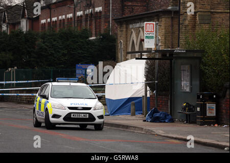 Une voiture de police garée près d'une tente judiciaire à Old Trafford, dans le Grand Manchester, où un 18 ans a été poignardé à mort hier. Banque D'Images