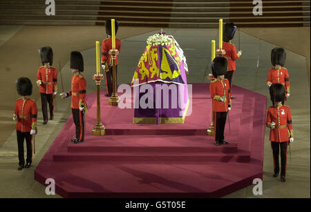 Le drapeau a drapé le cercueil de la reine Elizabeth la reine mère, se dresse à Westminster Hall, Londres, entouré par des gardes irlandais. Les funérailles de la reine mère auront lieu plus tard aujourd'hui à l'abbaye de Westminster. Banque D'Images