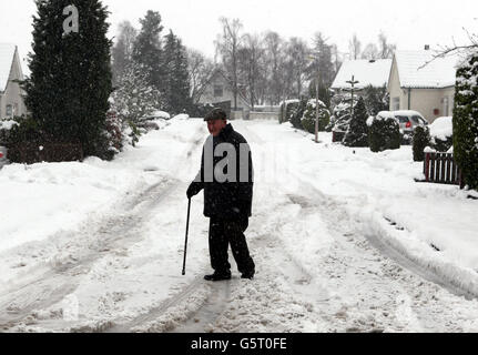 Un homme âgé traverse une route enneigée à Auchterarder après de fortes chutes de neige pendant la nuit. Banque D'Images