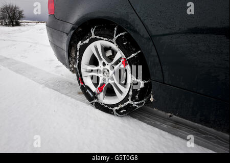 LES chaînes à neige THULE CG-9 sont montées et auto-tendues sur la roue motrice arrière d'une BMW. Les chaînes à neige facilitent la conduite dans la neige, en particulier sur les véhicules à propulsion arrière, qui sont beaucoup plus enclins à se coincer en raison d'une perte de traction. Banque D'Images