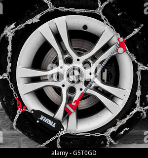 LES chaînes à neige THULE CG-9 sont montées et auto-tendues sur la roue motrice arrière d'une BMW. Les chaînes à neige facilitent la conduite dans la neige, en particulier sur les véhicules à propulsion arrière, qui sont beaucoup plus enclins à se coincer en raison d'une perte de traction. Banque D'Images
