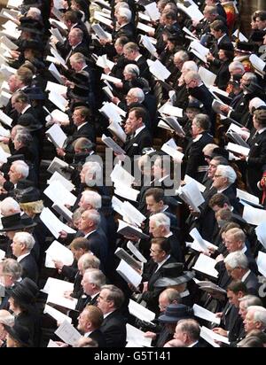 Les membres de la congrégation chantent ensemble, pendant les funérailles de la reine Elizabeth de Grande-Bretagne, la reine mère à l'abbaye de Westminster de Londres. Banque D'Images