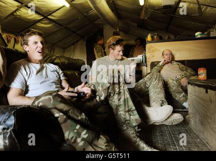 Le Prince (au centre) Harry ou tout simplement le Capitaine Wales comme il est connu dans l'Armée britannique, se détend pendant le jeu de football par ordinateur avec ses collègues pilotes d'hélicoptères Apache le Capt Simon Beattie (à gauche) et le Sergent James John (à droite), pendant leur 12 heures VHR (très haute disponibilité) Quart de travail à la ligne de vol contrôlée britannique dans le camp Bastion, dans le sud de l'Afghanistan, où il sert comme pilote d'hélicoptère Apache/Gunner avec 662 corps de l'armée de l'air SQD, de septembre 2012 pendant quatre mois jusqu'à janvier 2013. Photo datée du 03/11/2012 Banque D'Images